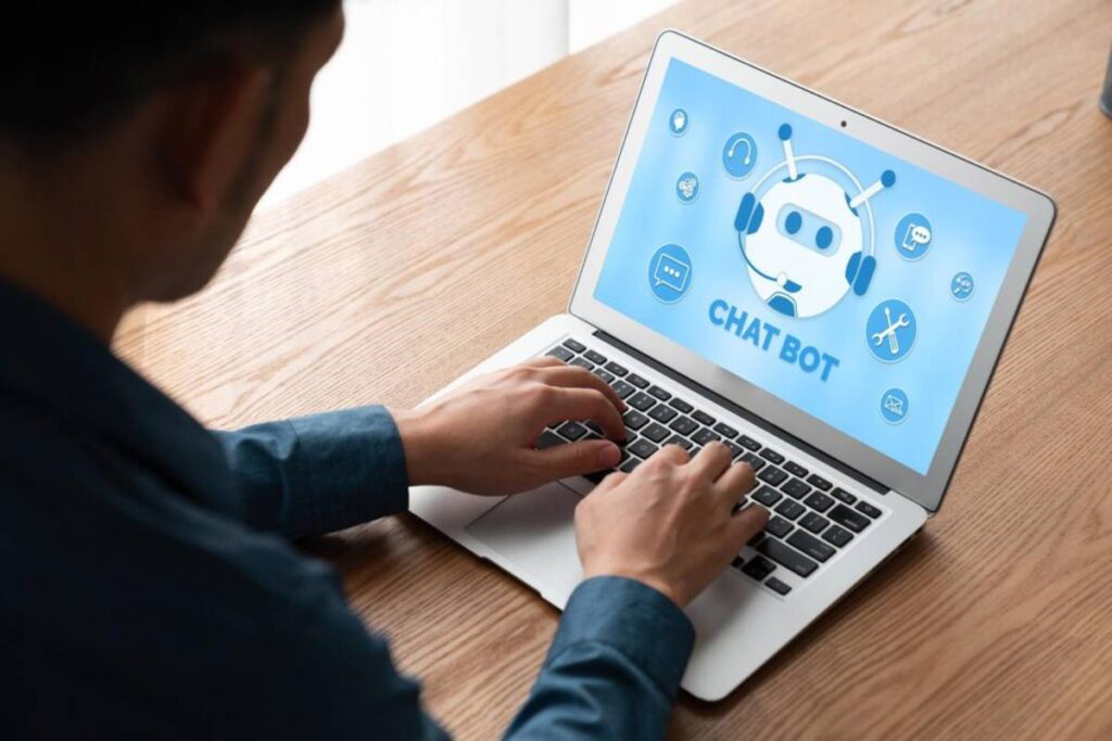 Man using laptop displaying chatbot interface with icons for communication tools.