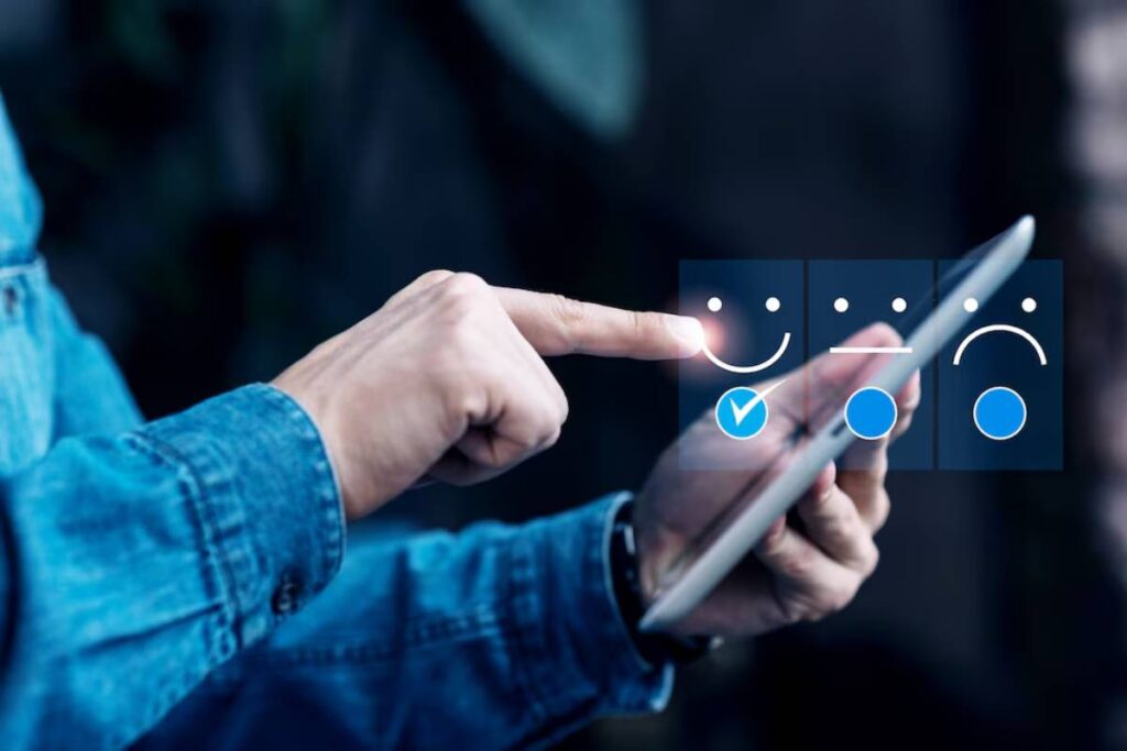 Person in a denim jacket using a tablet with a digital feedback survey interface displayed on the screen.