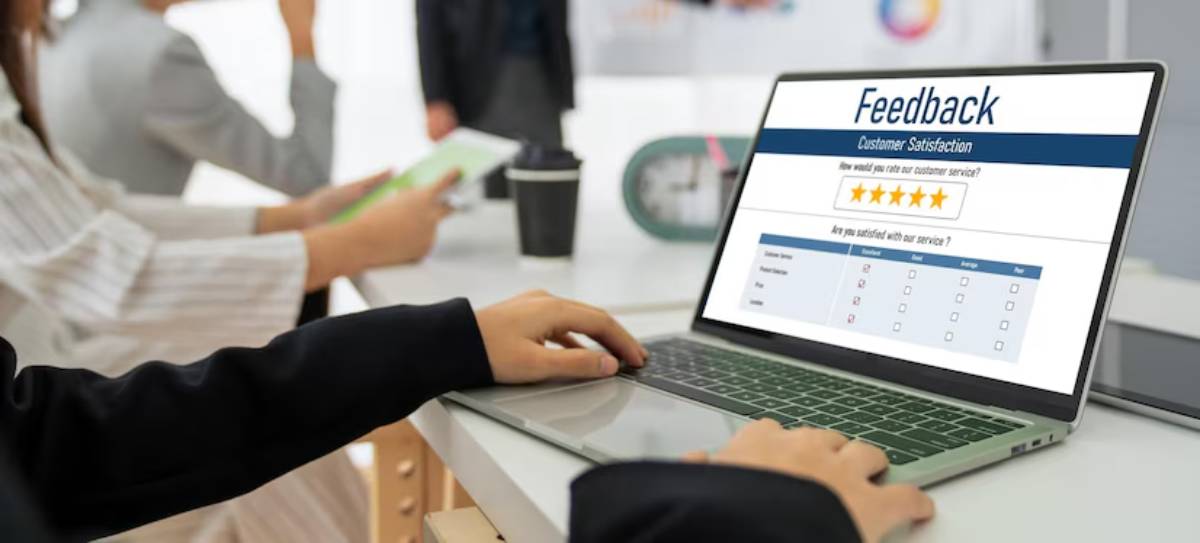 Business professionals gathering feedback on customer satisfaction using a laptop in a modern office setting.