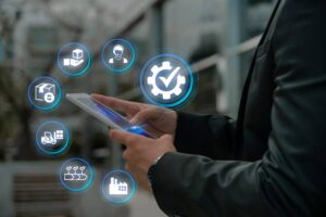 Businessman using a smartphone with futuristic digital technology icons surrounding it.