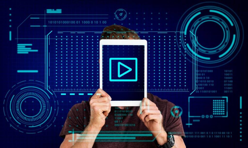 Man holding tablet in front of face with play button on screen, blue digital background with futuristic interface elements.