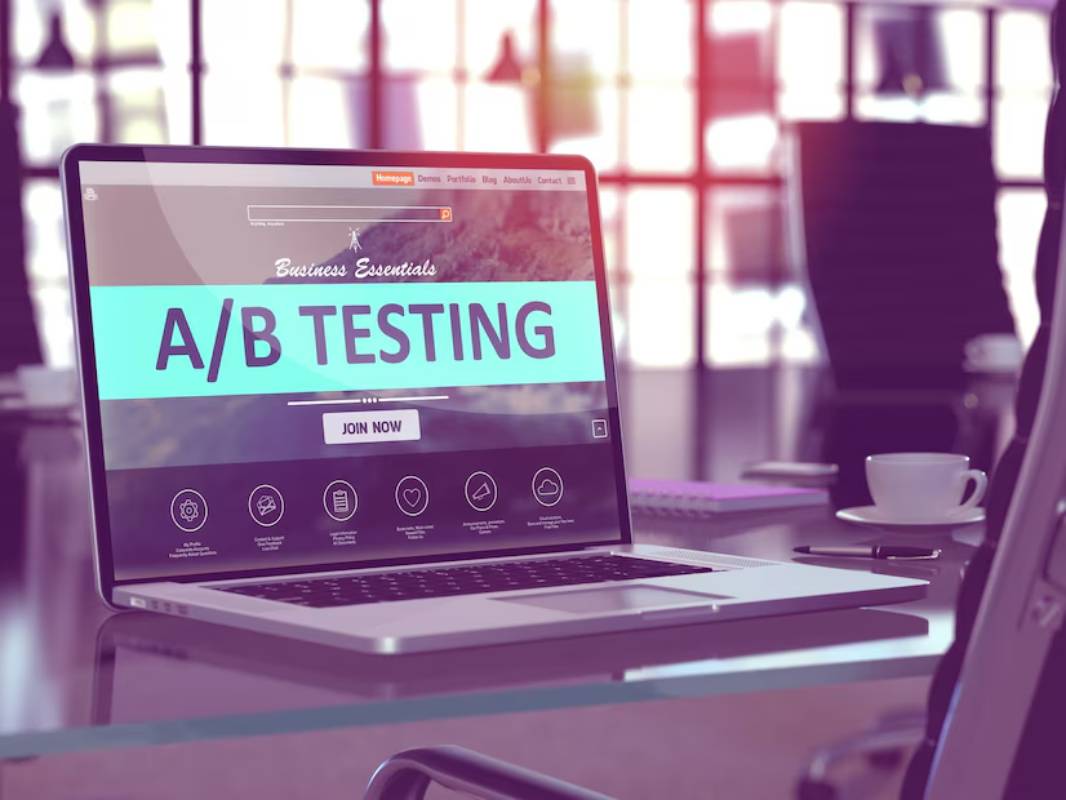 Laptop on a desk displaying a website about A/B testing; a blurred office background.
